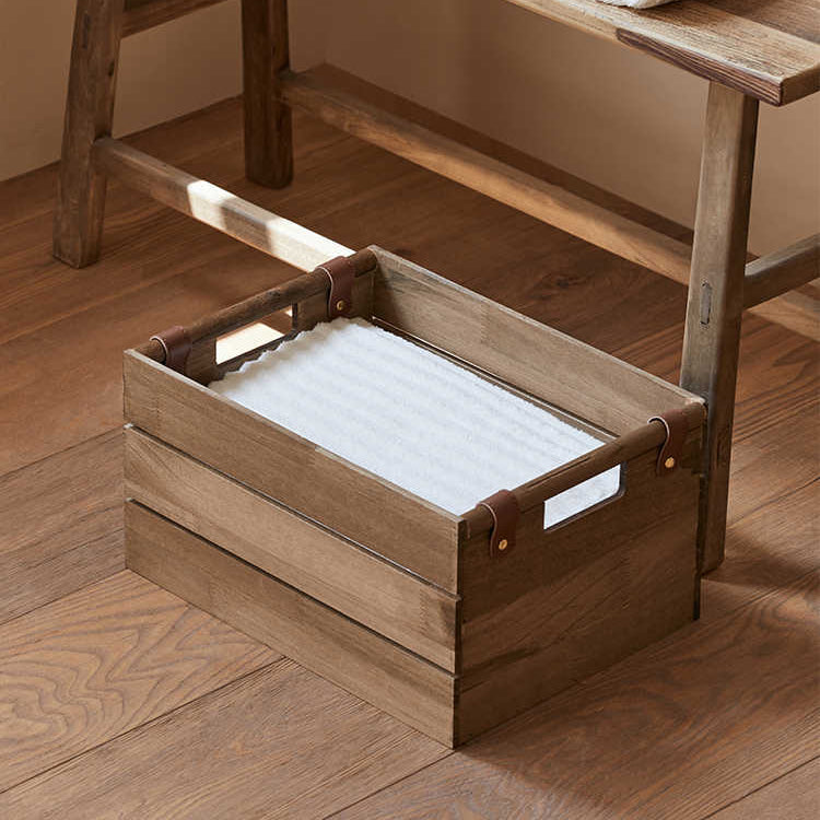 Wooden step stool with storage crate and towels on a wooden floor