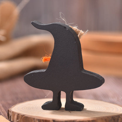 Black moon-shaped figurine on a wooden base with blurred background