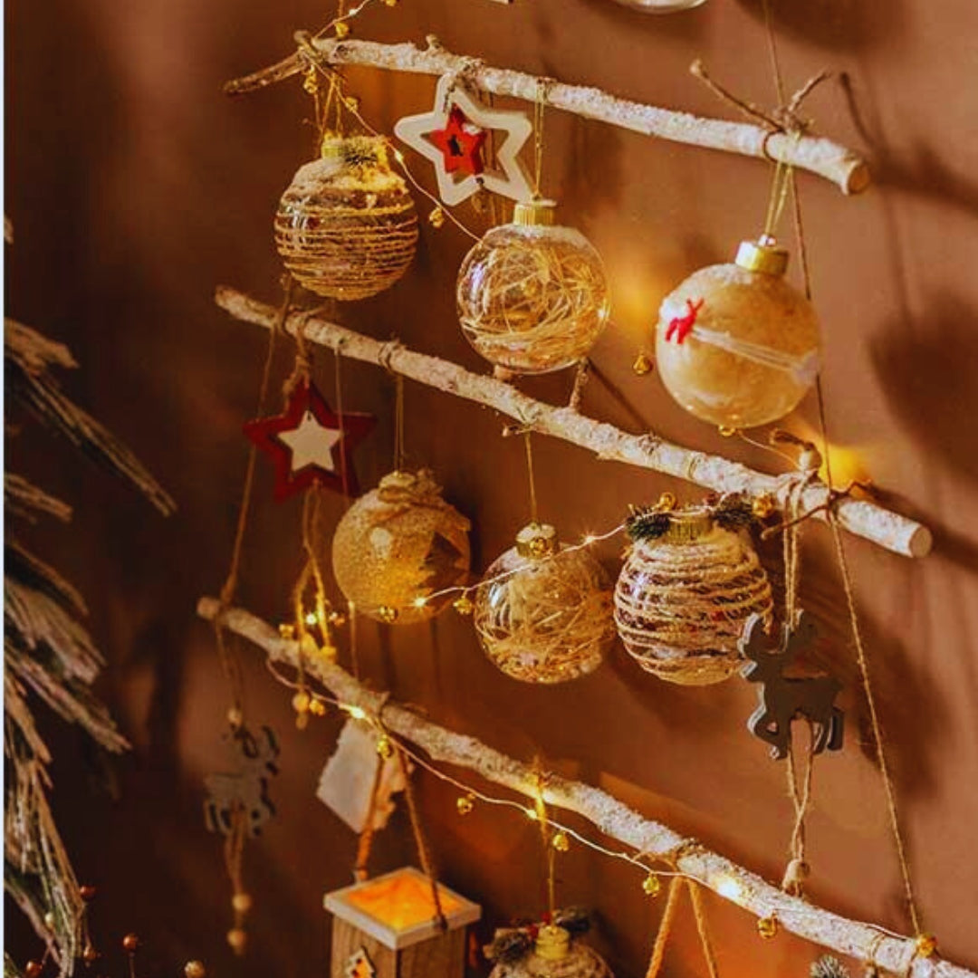 Decorative Christmas ornaments hanging on a branch with warm lighting