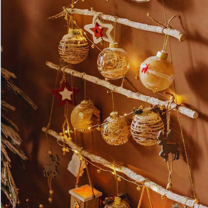 Decorative Christmas ornaments hanging on a branch with warm lighting